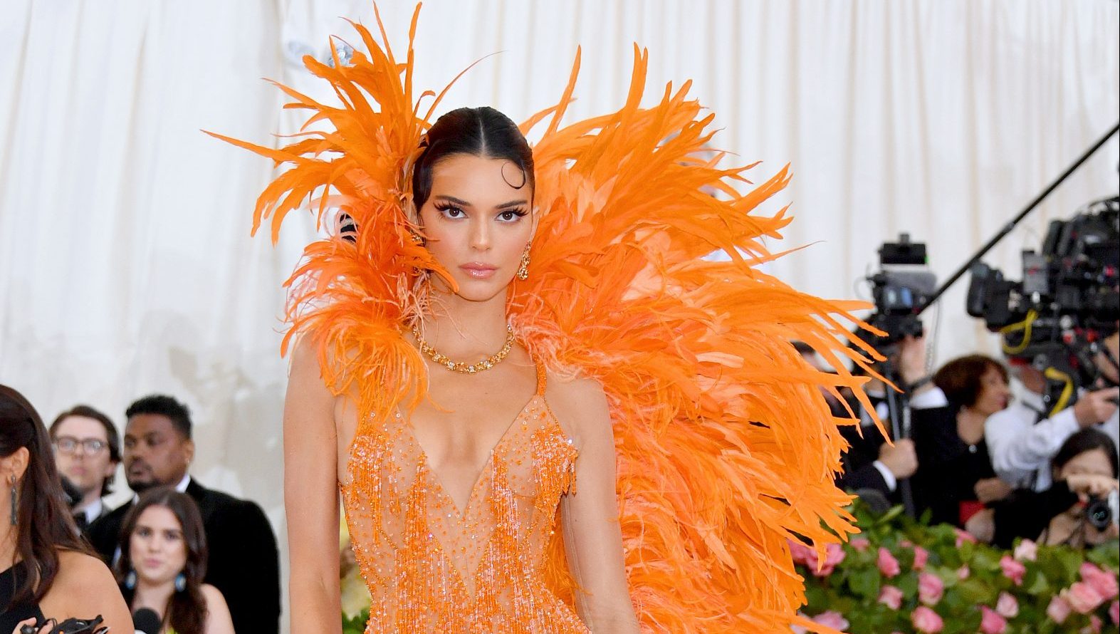 kendall jenner orange feather dress Kendall Jenner really took the 2019 'Camp: Notes on Fashion' Met Gala theme and ran with it Kendall showed up on the red carpet wearing a sleeveless, luminous orange dress, that