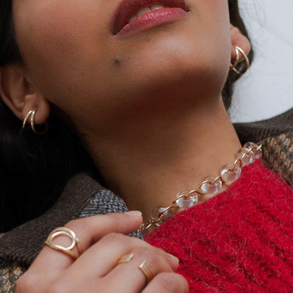 Quartz Poise Collar Necklace in gold by jewellery brand Skomer Studio, worn by model alongside the Weave Ring, the Column Ring and the Wave Hoop Earrings